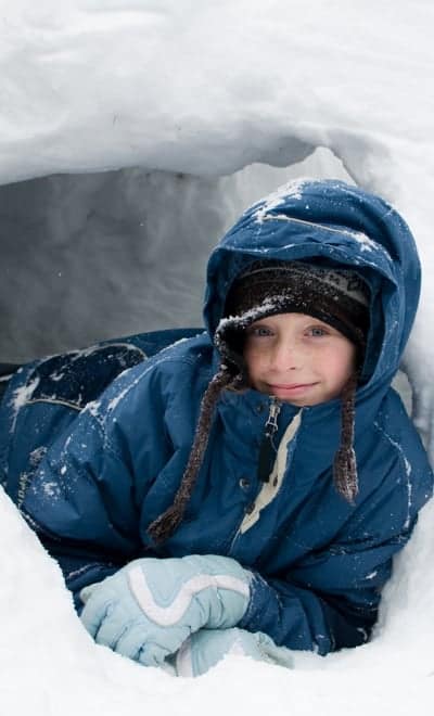 Child at Mount Washington BC building snow caves
